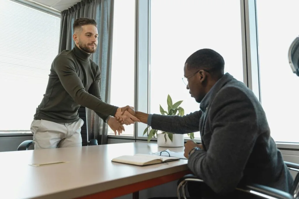 A person attending interview shaking hands with interviewer